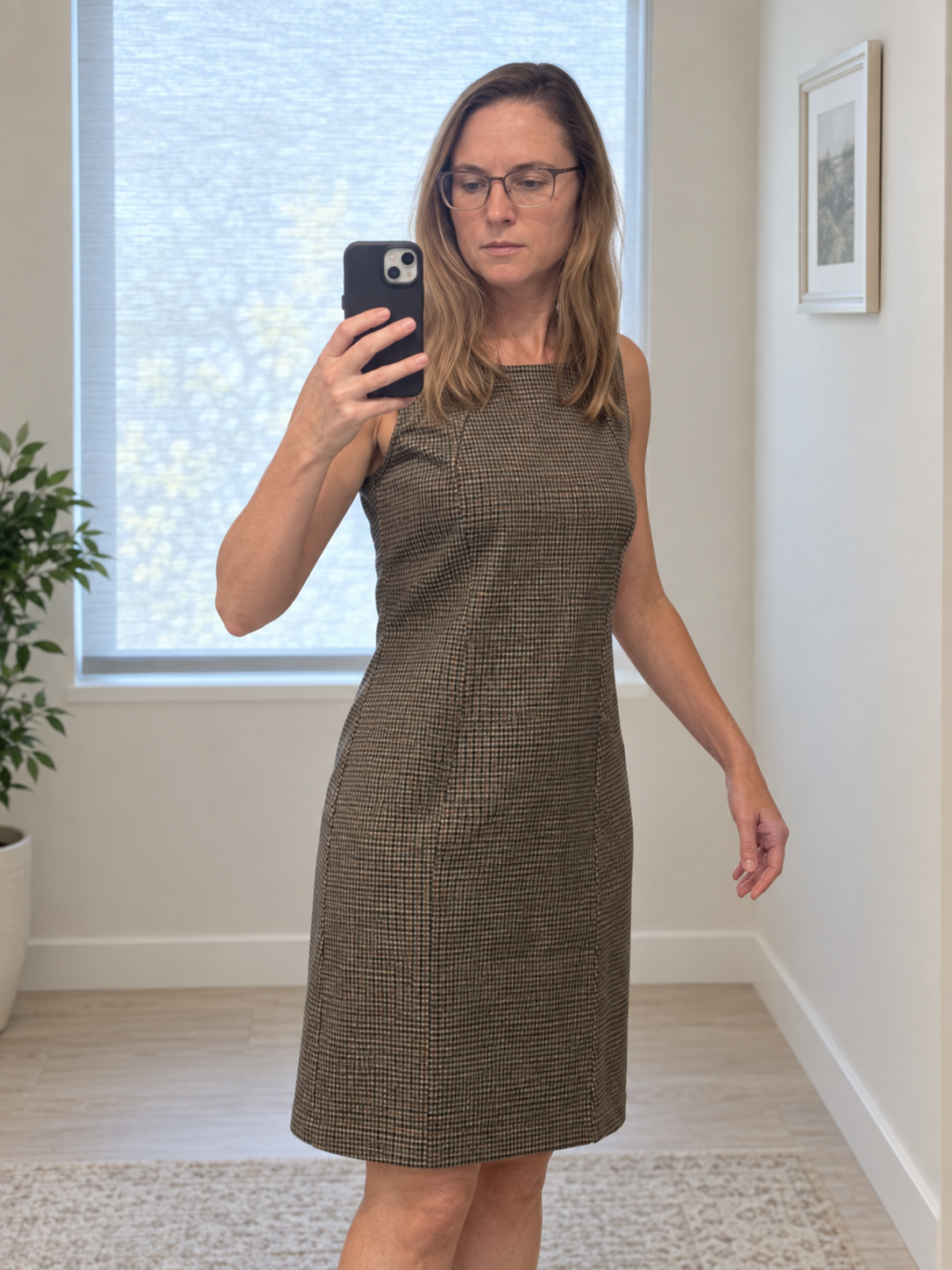 Katie taking a mirror selfie in her sleeveless checked Matty M dress from Costco.