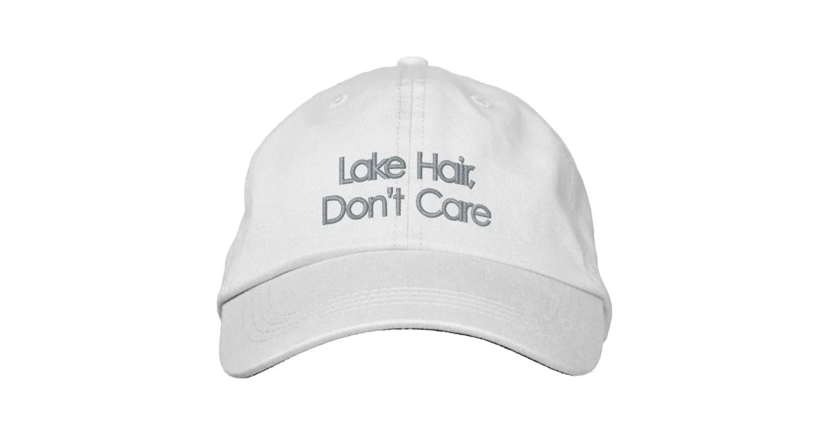 White low-profile baseball cap embroidered with Lake Hair, Don't Care